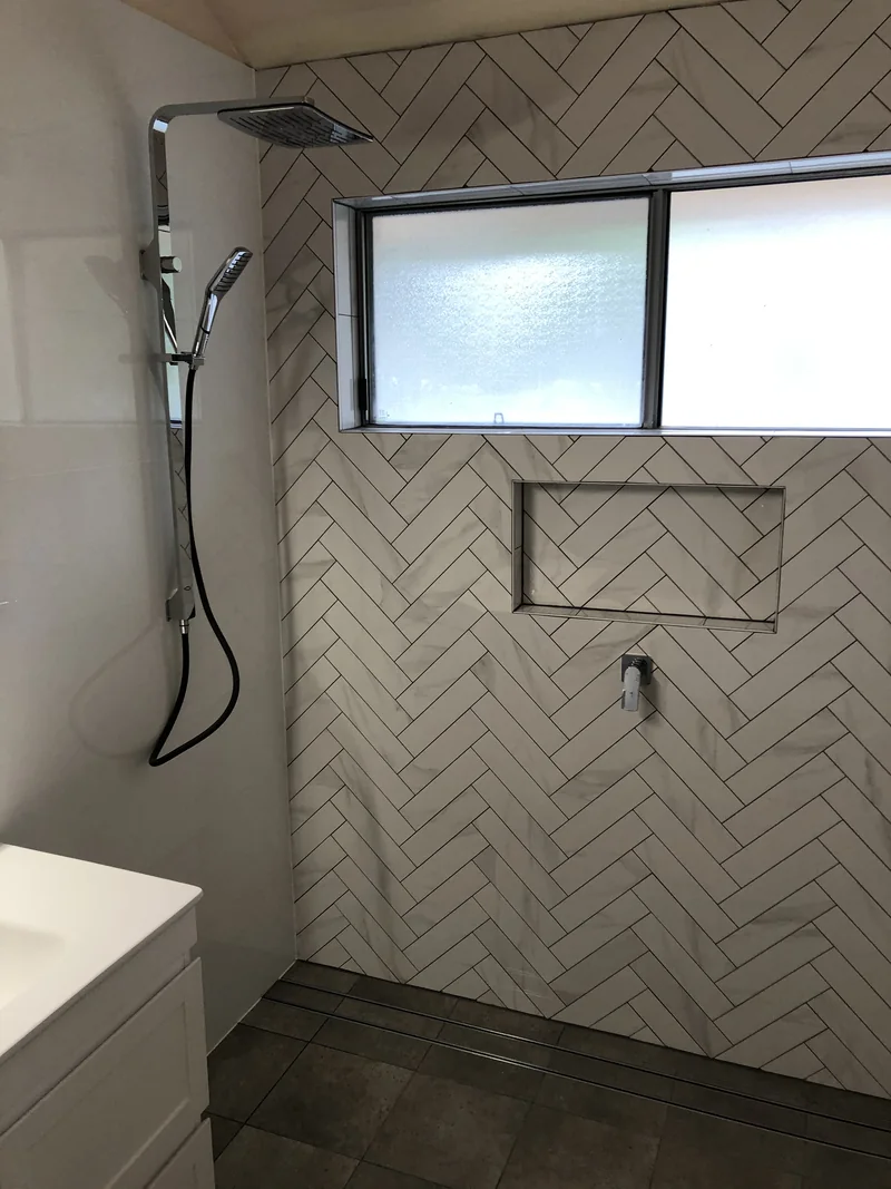 Herringbone feature wall and recessed shower niche after the Avoca Beach bathroom renovation