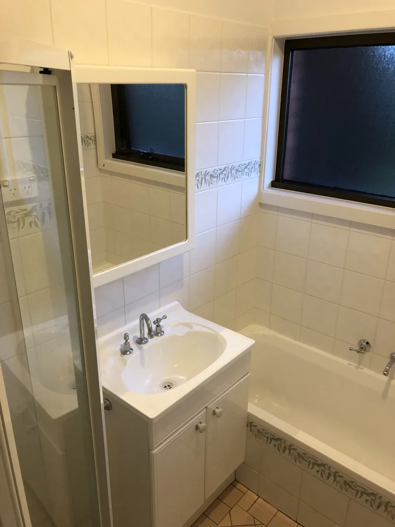 Built-in bath and small vanity before the Lisarow bathroom renovation
