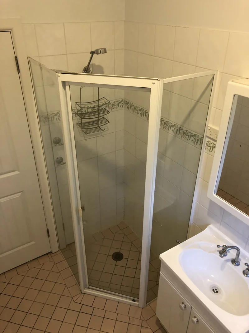 Framed corner shower before the Lisarow bathroom renovation