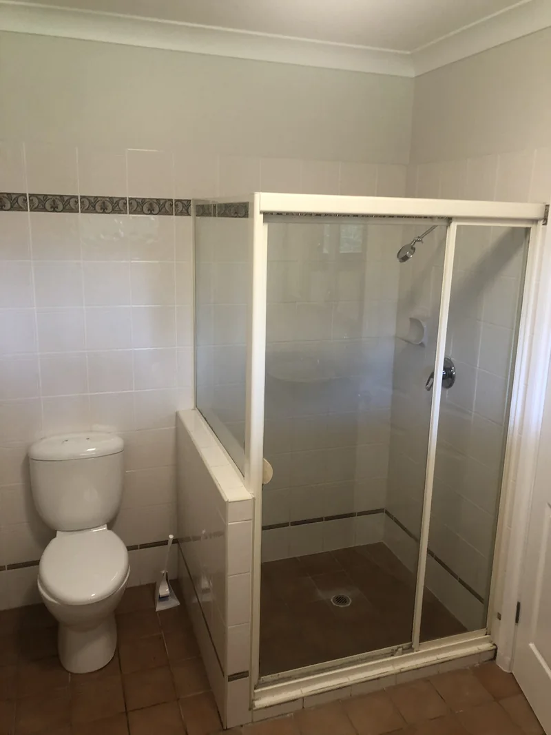 Framed shower and toilet before the ensuite renovation in Terrigal